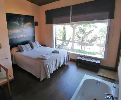 Foto de la habiatción con bañera de hidromasaje al lado de la cama de las Casas Rurales Los Cortijos