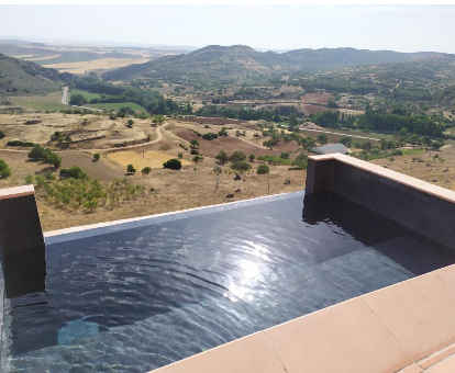 Foto de la piscina infinita con bellas vistas de las Casas Rurales Planeta Chicote