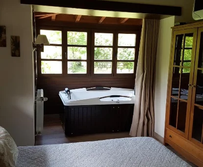Foto de la habitación con jacuzzi al lado de la cama de las Casas rurales Valle de Bueida  