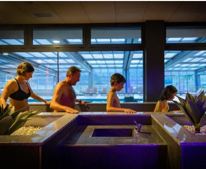 Foto de una familia disfrutando de un circuito de agua en el spa del resort Cerdanya EcoResort 
