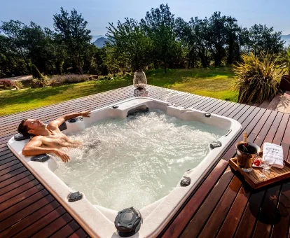 Foto de un hombre relajándose en el jacuzzi exterior de la casa rural Estança La Pau - Adults Only 
