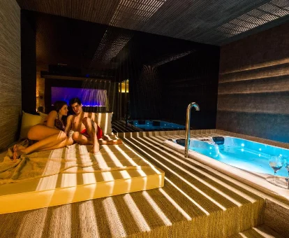 Foto de una pareja relajándose junto al jacuzzi que se encuentra en el Hotel Spa Balfagon 
