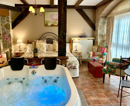 Foto de la habitación con bañera de hidromasaje al lado de la cama que se encuentra en La Casa Del Puente 
