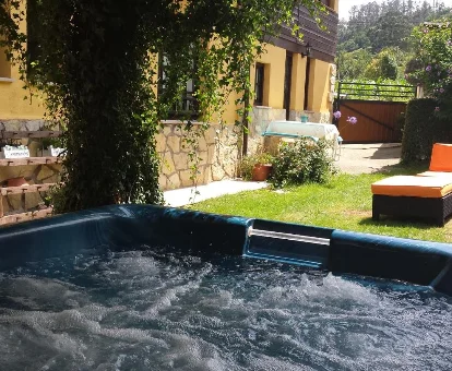 Foto del jacuzzi de exterior en el jardín de la casa La Fragua del Canajal apartamentos 

