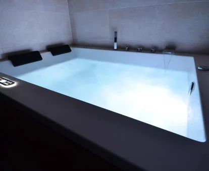 Foto de la bañera de hidromasaje con iluminación ambiental de la casa rural La Granja del Besa 