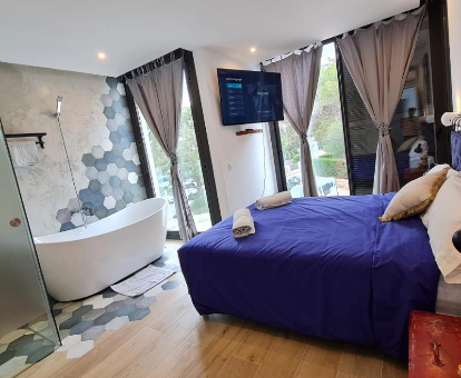 Foto de la habitación con bañera cerca de la cama de la casa Mitjana's House