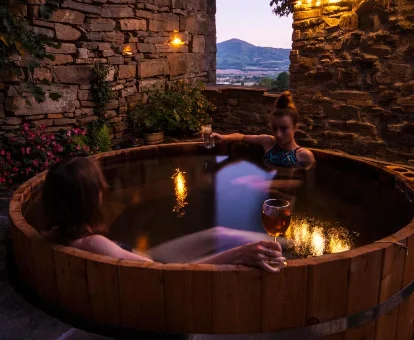 Foto de ina pareja relajándose en una gran balera tipo barril de la casa O Chardinet d'a Formiga 
