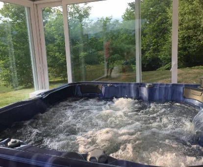 Foto del jacuzzi cubierto con vistas de la casa Os Tres Teixos