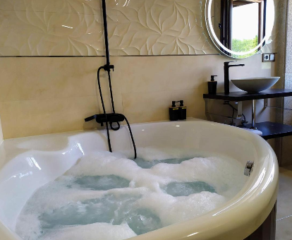 Foto de la bañera de hidromasaje con espeuma del REMANSO DE TRASFONTAO Casa das Árbores & Bubble