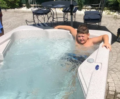 Foto de un niño dándose un baño en el jacuzzi exterior de la Villa Rosa  