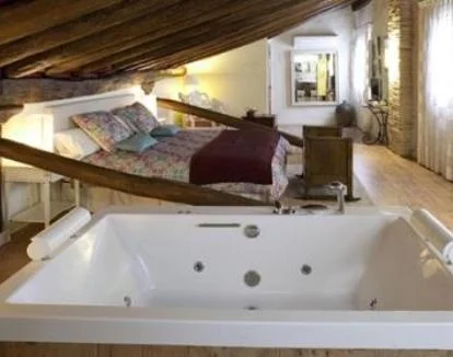 Foto del amplio jacuzzi privado junto a la cama de la Suite del alojamiento.