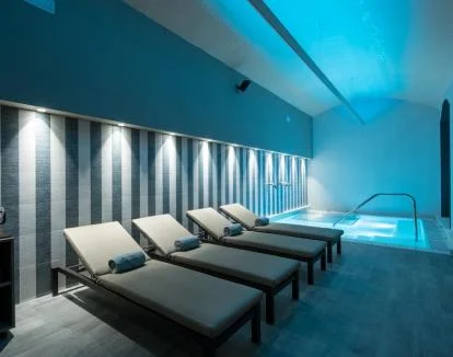 Foto del acogedor spa con piscina cubierta y zona de relajación.