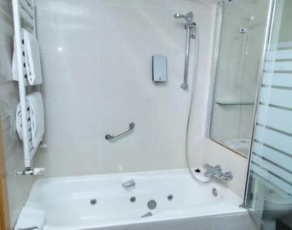 Foto de la Suite Junior con jacuzzi privado y vistas al mar desde la cama.