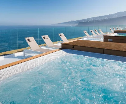 Piscina de sensaciones al aire libre rodeada de tumbonas en Hotel Atlantic Mirage Suites & SPA