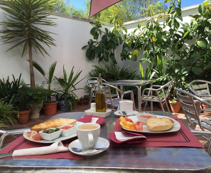 Zona de comedor al aire libre del hostal con servicios de spa Ben-Nassar en Arjona