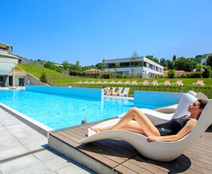 Piscina exterior rodeada de jardines en Gran Hotel Las Caldas Wellness Clinic