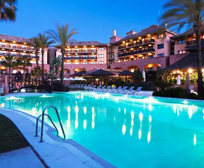 Piscina al aire libre con zona de tumbonas rodeada de las habitaciones del DoubleTree by Hilton Islantilla Beach Golf Resort