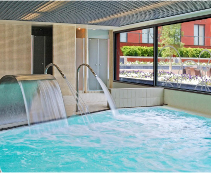 Piscina con fuentes, chorros y regaderas de agua ubicada en el spa del Hotel DoubleTree en Sant Esteve Sesrovires