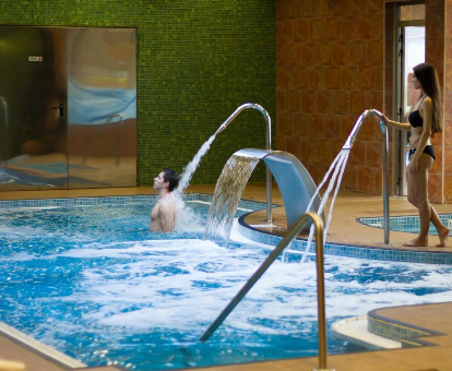 Piscina con chorros de agua y fuente ubicada en el spa del Hotel Golden Port Salou & Spa en Saliou
