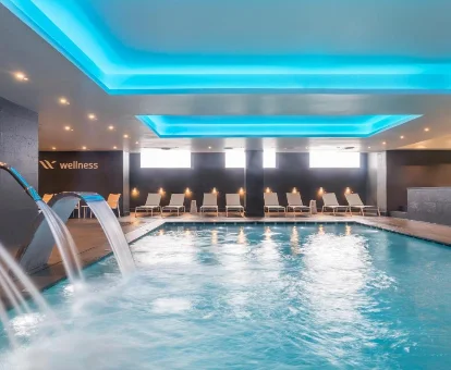 Área de piscina con cascadas y tumbonas en Barceló Aracena 
