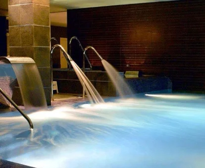 Piscina con fuente y chorros de agua situada en el spa del Hotel HG La Molina en La Molina