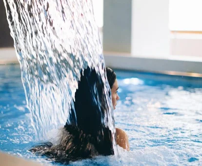 Piscina interior con regadera del hotel con spa Manantial en Caldes de Boi
