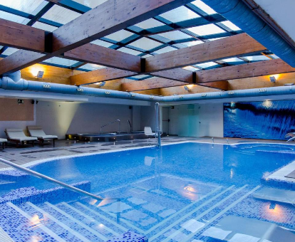 Piscina interior con chorros, fuentes y regaderas de agua del spa en el Hotel Villa Olimpica Suites