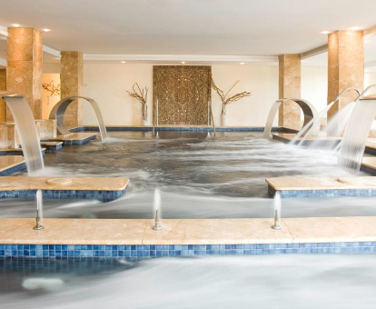 Piscina interior con duchas, fuentes, chorros de hidromasaje del Insotel Fenicia & Spa en Santa Eularia des Riu