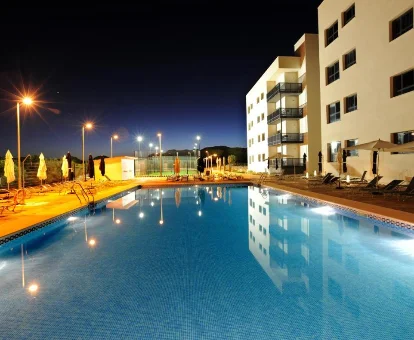 Noche en área de piscina con tumbonas y caminerías en Leo Deluxe Punta Umbría