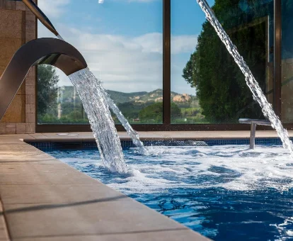 Piscina interior con duchas para masajes del Spa del Hotel Mas Tapiolas en Santa Cristina d'Aro