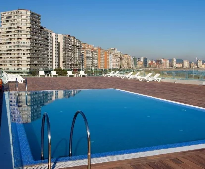 Piscina Exteriorr con vista a la ciudad en el hotel NH Gijón