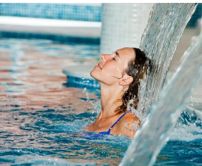 Piscina interior con fuentes de agua localizada en el spa del Hotel Sagitario Playa en Cala Blanca