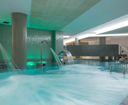 Piscina interior con duchas sensaciones perteneciente al spa ubicado en el hotel Sercotel Odeón en Narón