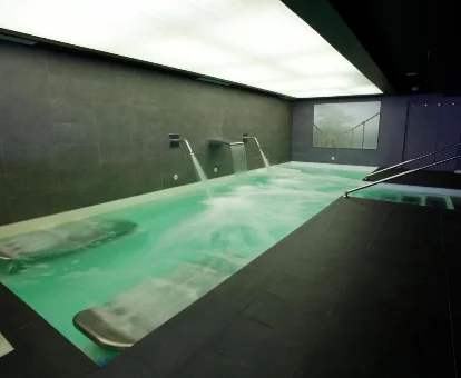 Piscina con fuentes, paletas y regaderas ubicada en el spa del Hotel Sinagoga en Hervás