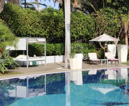 Área de la piscina al aire libre con tumbonas y toldos en Sir Anthony