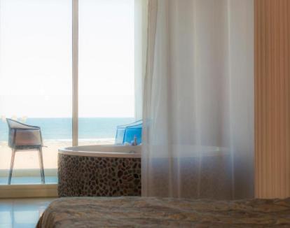 Foto de la Suite con vistas al mar y jacuzzi privado junto a la cama.