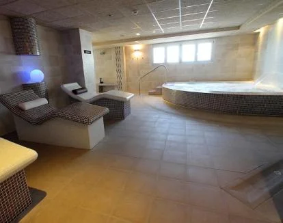 Foto de la zona de bienestar del hotel con jacuzzi y tumbonas.