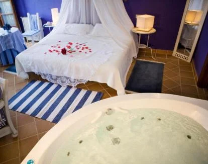 Foto de la Habitación Doble Premium con jacuzzi privado junto a la cama y balcón con vistas a la naturaleza.