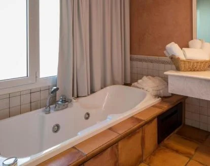 Foto de la elegante Suite Doble Deluxe con jacuzzi privado y terraza con vistas a la montaña.