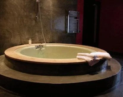 Foto de la Suite una amplia estancia con chimenea, jacuzzi privado y balcón con vistas al campo.