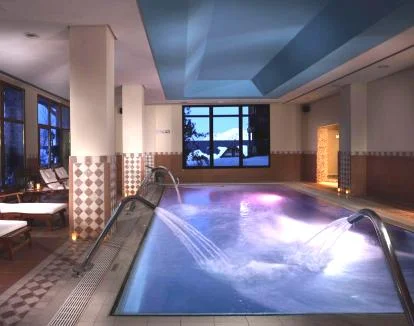 Foto de la piscina cubierta del spa con chorros y zona de relajación.
