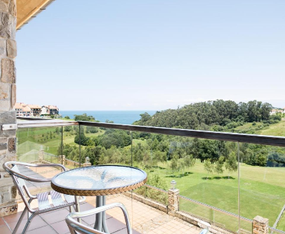 Foto de las vistas al mar y a la colina desde la terraza de una habitación del Abba Comillas Golf Hotel
