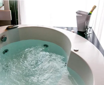 Foto del jacuzzi privado con una botella de champán y dos copas que se encuentra en el Acacias Hotel Suites & Spa