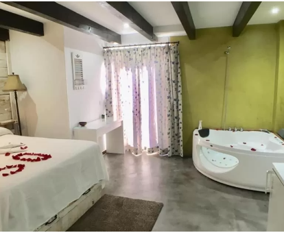 Foto de la habitación con bañera de hidromasaje privada cerca de la cama del Albergue Boi Romanic Suites