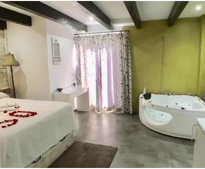 Foto de la habitación con bañera de hidromasaje privada cerca de la cama del Albergue Boi Romanic Suites