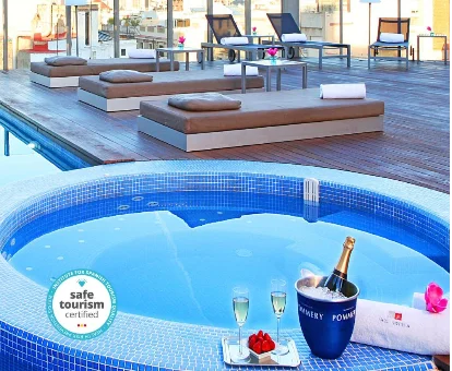 Foto del jacuzzi con chorros de agua y una piscina al aire libre con tumbonas en el hotel solo para adultos Axel Hotel Barcelona