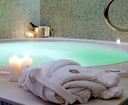 Foto de la bañera de hidromasaje redonda con luces ambientales y velas aromáticas que se encuentra en el hotel Axor Barajas