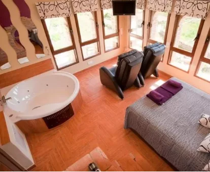 Foto de la habitación matrimonial con jacuzzi cerca de la cama de la Casa Rural Caseta de l' Hort 
