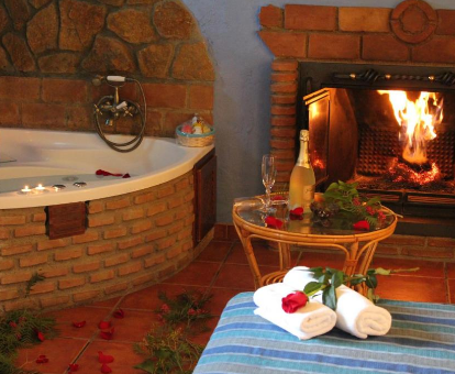 Foto de la bañera de hidromasaje junto a la chimenea en una de las habitaciones del hotel rural Casas Cueva Cazorla
