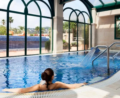 Foto de una mujer en la piscina cubierta del Denia Marriott La Sella Golf Resort & Spa 
